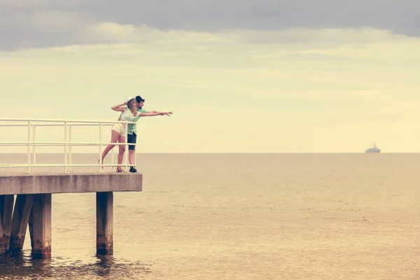 Kärleksfull hipster par på piren i havet — Stockfoto