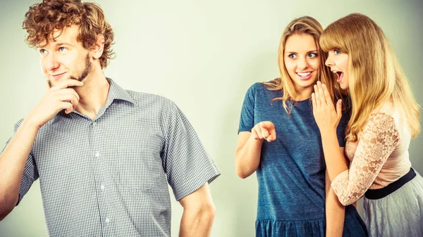 Dos mujeres hablando chismes sobre el hombre . — Foto de Stock