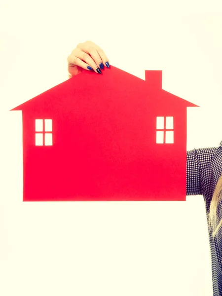 Mano femenina sosteniendo el símbolo de la casa de papel rojo — Foto de Stock