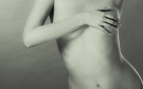 Health care medical concept. Close up young woman examining her breasts for lumps or signs of breast cancer