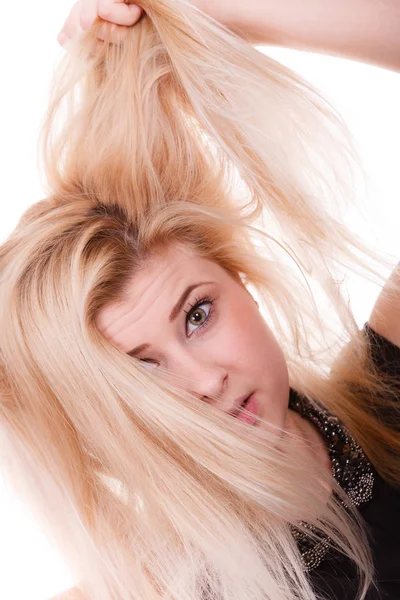 Blonde woman holding her dry hair