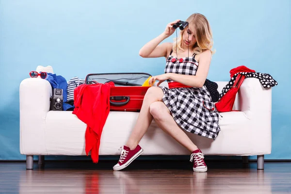 Young woman packing suitcase on couch — Stock Photo, Image