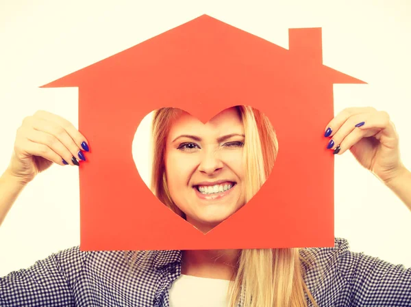 Lycklig kvinna håller rött papper hus — Stockfoto