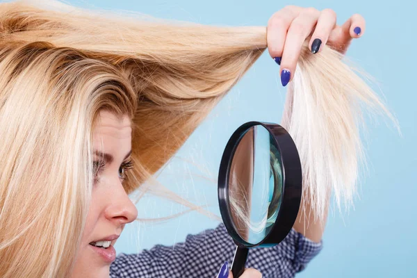 Kvinna tittar på hår genom förstoringsglas — Stockfoto