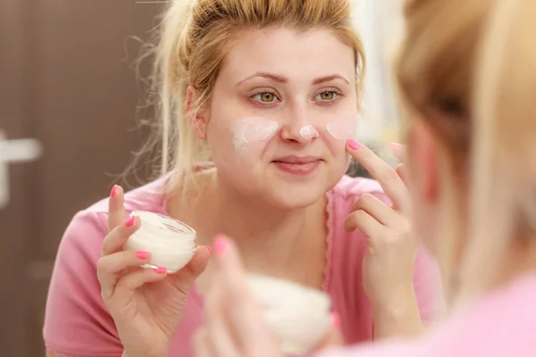 Žena použitím krém na obličej s prstem — Stock fotografie