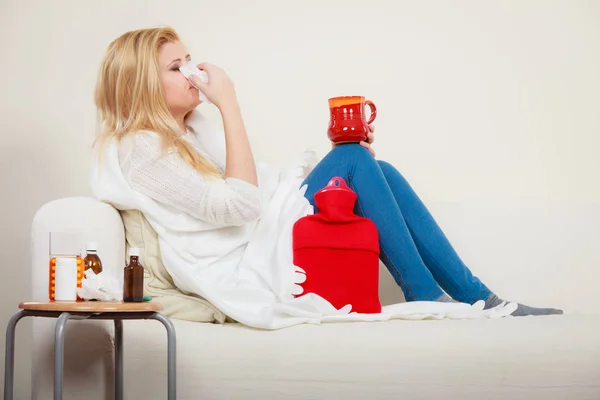 Mujer enferma teniendo gripe acostada en un sofá —  Fotos de Stock