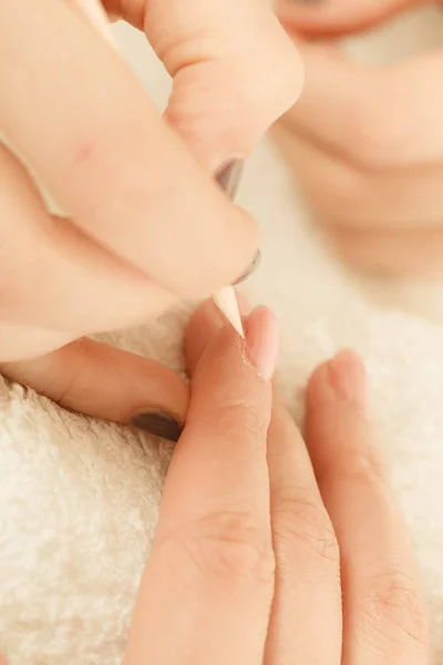 Beautician preparing nails before manicure, pushing back cuticles — Stock Photo, Image