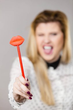 Sahte dudaklar sopa üzerinde tutan mutlu kadın