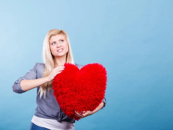 Donna felice che tiene il cuscino rosso a forma di cuore — Foto Stock