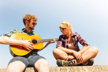 Genç kadın için gitar çalmak hipster adam.