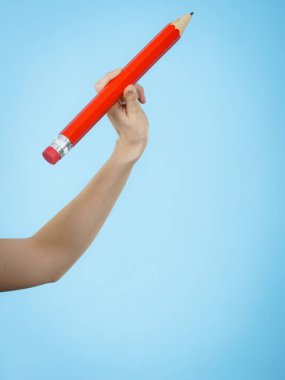 El büyük kırmızı kalem tutan