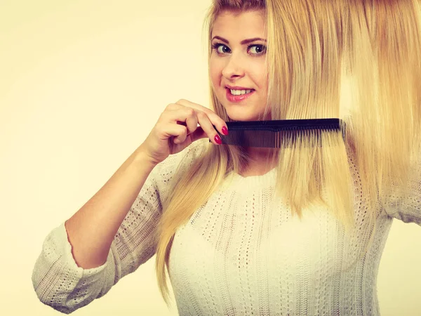 Mulher loira segurando o cabelo no cabide de roupas — Fotografia de Stock