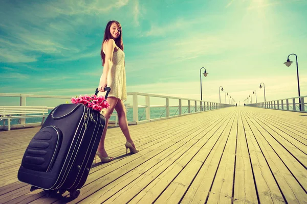 車輪の上のスーツケースと一緒に歩いている若い女性 — ストック写真