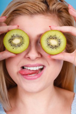 Gözlük gibi yeşil kivi tutan kadın