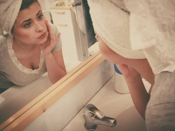 Vrouw kijkt naar haar reflectie in spiegel — Stockfoto
