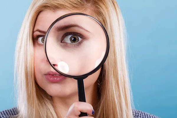 Frau schaut durch Vergrößerungsglas — Stockfoto