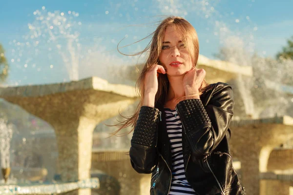 Casual stijl vrouw poseren tegen stad fontein — Stockfoto