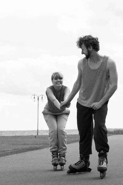 Mulher e homem casal rollerskates ao ar livre — Fotografia de Stock