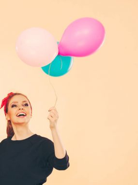 Balonlarla eğleniyor gülümseyen çılgın kız.