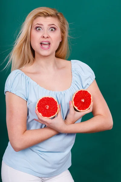 Женщина держит цитрусовые грейпфруты на груди — стоковое фото