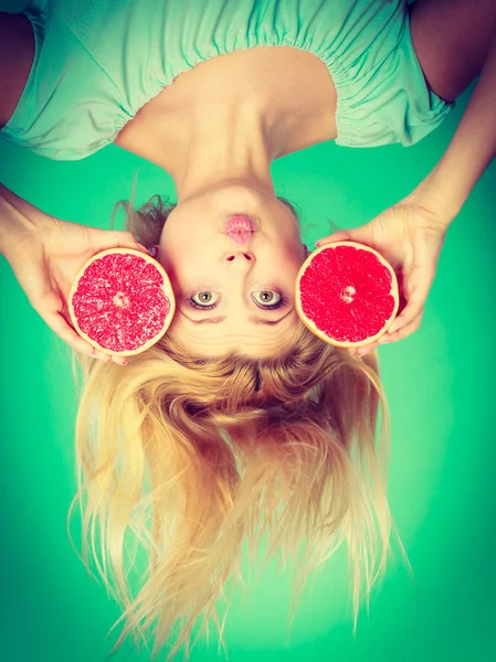 女人抱着红色葡萄柚，疯狂被风吹起的头发 — 图库照片