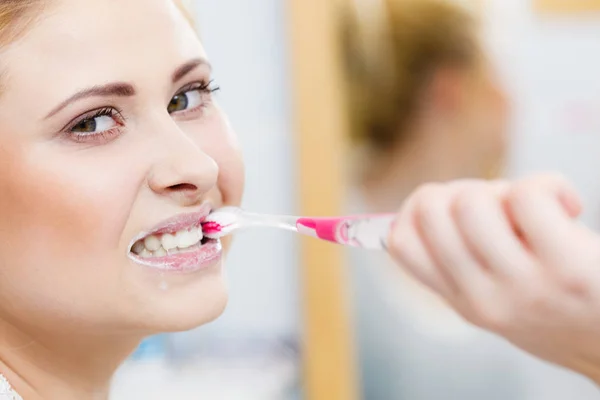 Woman brushing cleaning teeth in bathroom — Stock Photo, Image