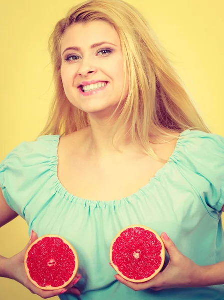 Kırmızı greyfurt meme üzerinde tutan kadın