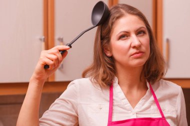 Ev kadını mutfakta kepçe ile