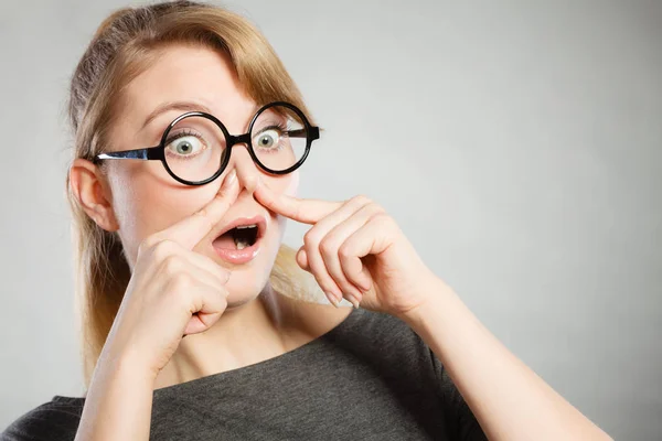 Girl pinches her nose because of stench stink.