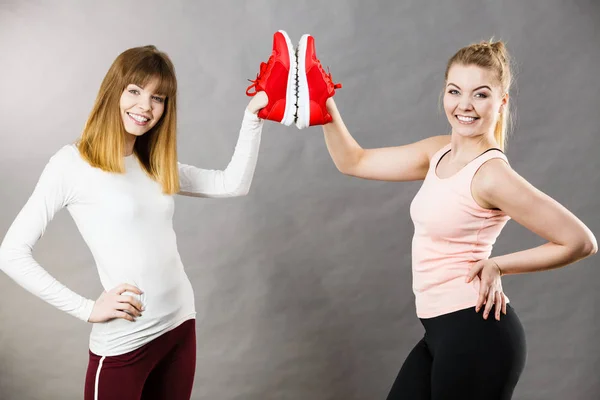 Zwei Frauen präsentieren Sportbekleidung Turnschuhe — Stockfoto