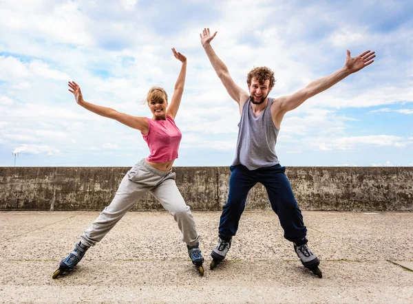 Zwei Personen auf Rollerblades mit ausgebreiteten Armen. — Stockfoto