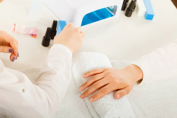 Mulher mão na toalha, ao lado do conjunto de manicure — Fotografia de Stock