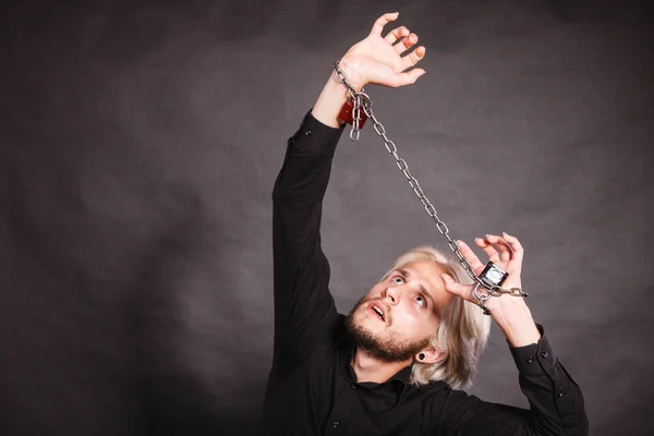 Furious man with chained hands, no freedom