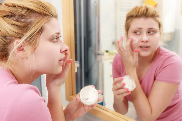 Mujer aplicando crema facial con el dedo — Foto de Stock