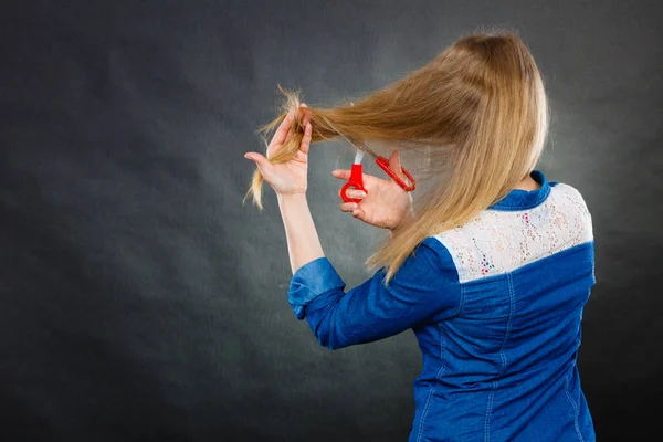 Blonda kvinnan klippa hennes hår. — Stockfoto