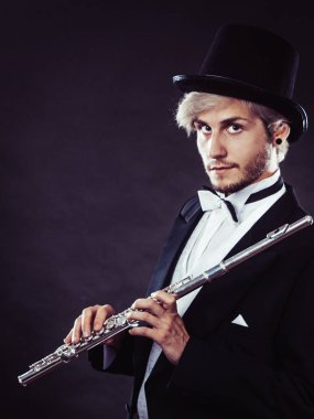 Zarif giyimli müzisyen flüt tutan