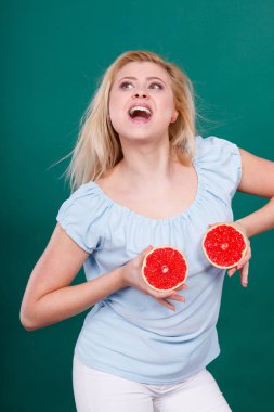 Kadın greyfurt narenciye meyve meme üzerinde tutar