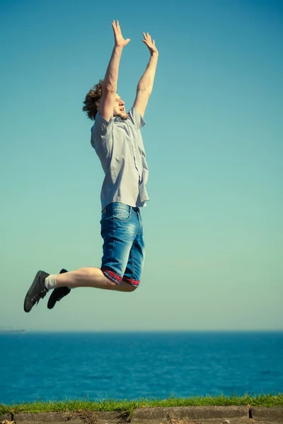 Carefree man jumping by sea ocean. — Stock Photo, Image