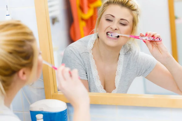 Woman brushing cleaning teeth in bathroom — Stock Photo, Image