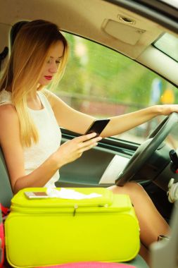 Arabasını kullanırken telefonu kullanan bir kadın.