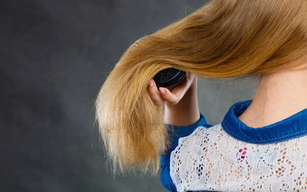 Blond kvinna kammar sitt hår. — Stockfoto