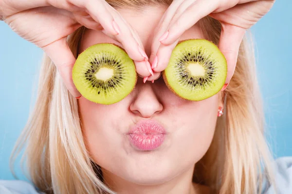 Vrouw met groene kiwi fruit zoals brillen — Stockfoto