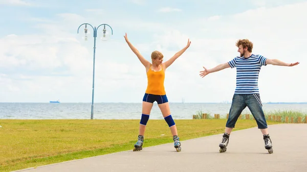 Jovem casal em patins andando ao ar livre — Fotografia de Stock