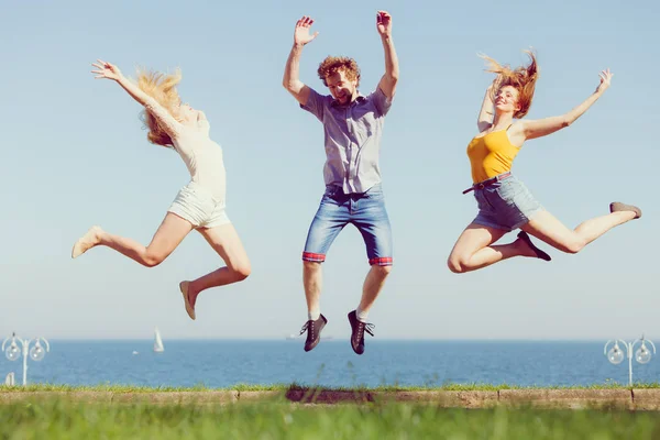 Gruppe von Freunden Junge zwei Mädchen springen im Freien — Stockfoto
