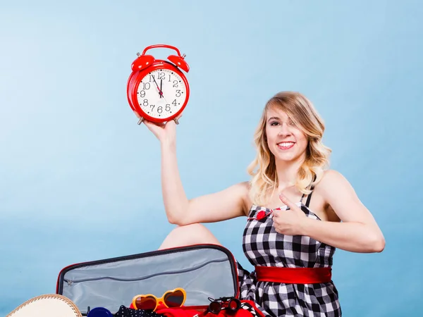 Woman sitting with suitcase holding old clock — Stock Photo, Image