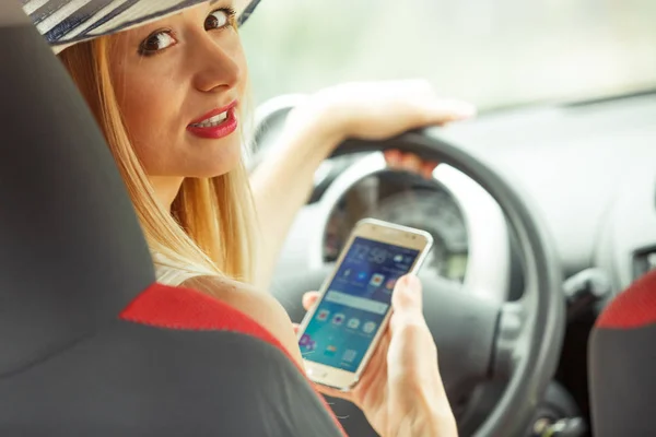 Mujer usando el teléfono mientras conduce su coche — Foto de Stock
