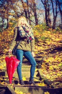 Parkta şemsiyeyle yürüyen kadın