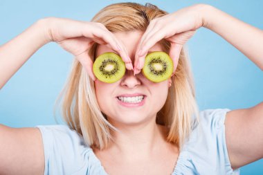 Gözlük gibi yeşil kivi tutan kadın