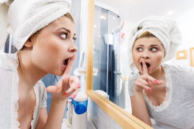 Bir kadın aynadaki yansımasına bakıyor.