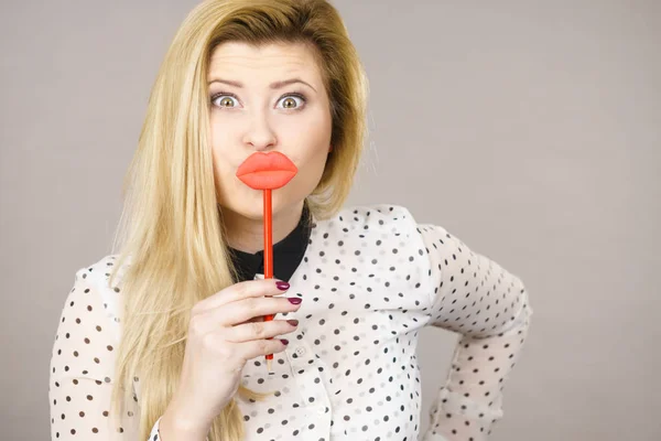 Happy woman holding fake lips on stick — Stock Photo, Image